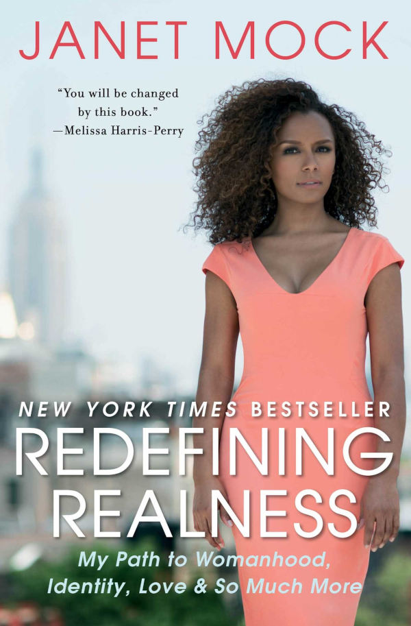 Book cover of “Redefining Realness” by Janet Mock showing Janet Mock in a coral dress standing outdoors with blurred city background and title text.