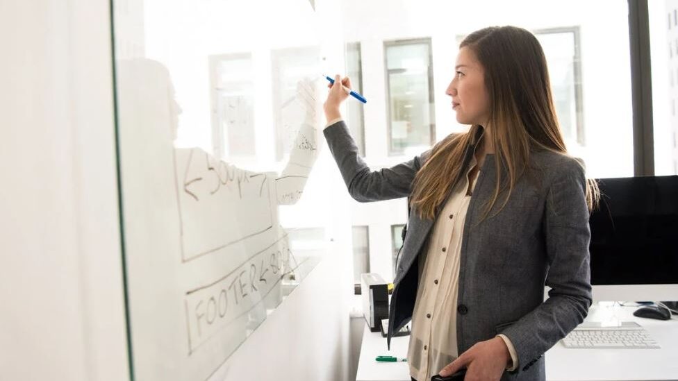 woman writing on a whiteboard