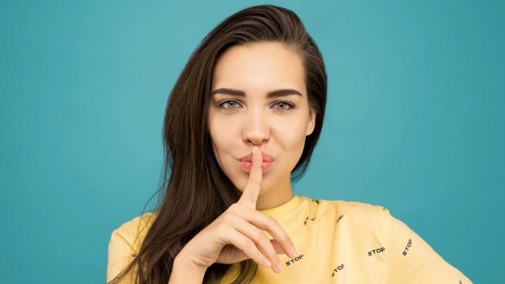 woman with a finger on the mouth