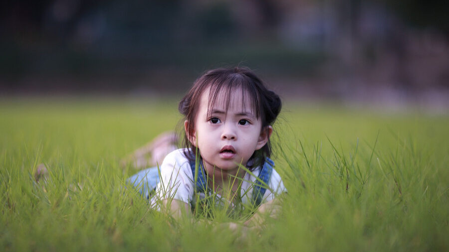 Young girl lying on the grass.