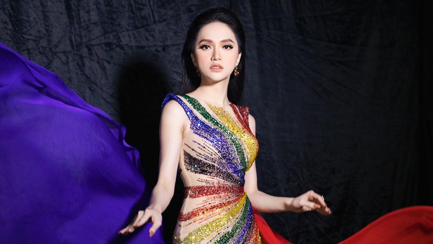 Nguyen Huong Giang wearing a stunning rainbow-colored gown, flowing dramatically with vivid colors symbolizing the LGBTQ+ pride flag. Image from Instagram @huoggiangggg