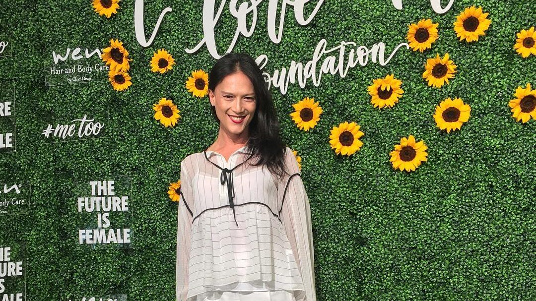 BB Gandanghari at the "I Love Me Foundation" event, standing in front of a green backdrop adorned with sunflowers, wearing a light and airy outfit.