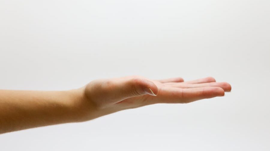 A neutral gesture of an open hand with light skin tone, shown from the side against a blank white backdrop.