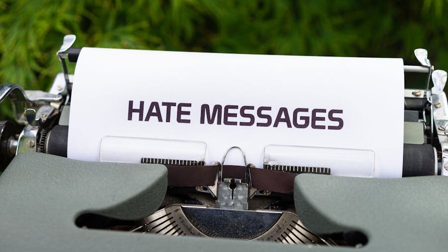 Vintage typewriter with a typed sheet showing the words "HATE MESSAGES," placed outdoors.