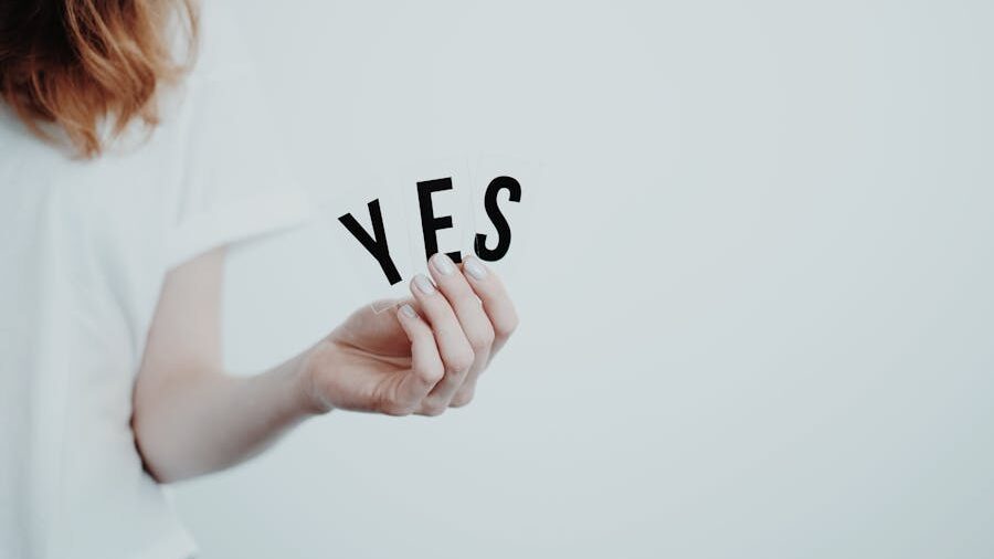 Person holding individual letters spelling out “YES,” with a minimalist background.