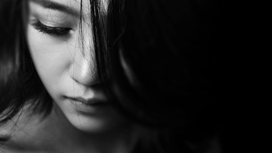 Black-and-white close-up of a woman with soft features, looking down thoughtfully.