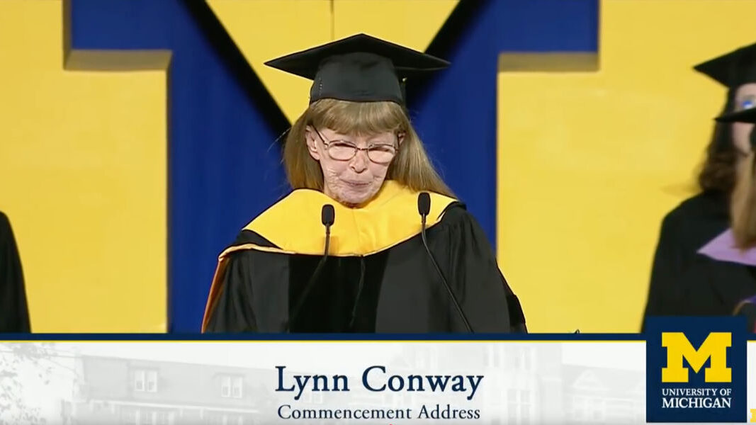 Lynn Ann Conway delivering the Winter Commencement Address at the University of Michigan in 2018, wearing academic regalia and standing at a podium.