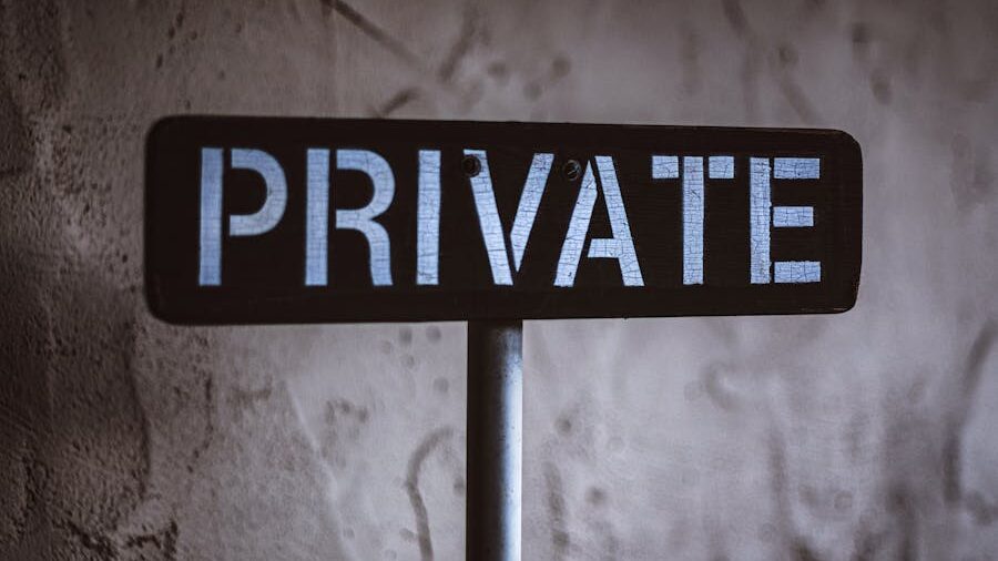 A dark wooden sign with "PRIVATE" written prominently, standing in a dimly lit setting.