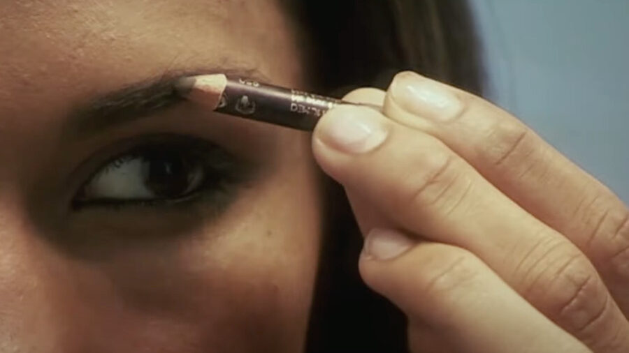 Close-up of Miriam Rivera applying eyebrow pencil, as seen in “Miriam: Death of a Reality Star.”