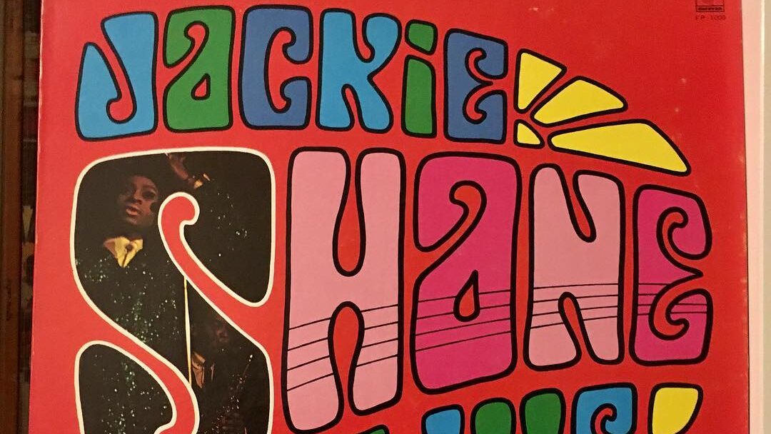 A vintage album cover of Jackie Shane featuring bold, colorful typography on a red background.