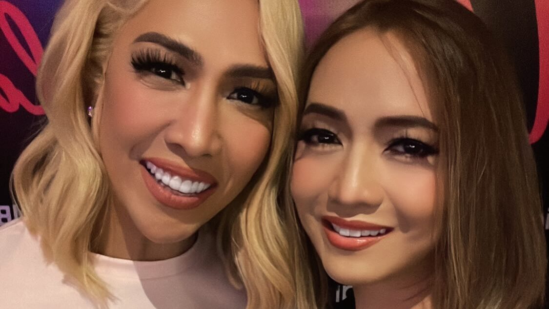 Public figures Vice Ganda and Anton Diva photographed together smiling at social gathering, indoor nightlife background.