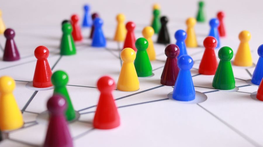 Red, blue, green, yellow, and purple game pieces linked by lines across a white background representing connections.