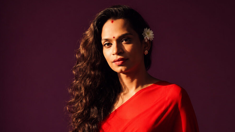 Chandramukhi Muvvala wearing a red sari and flowers in her hair during a studio portrait.