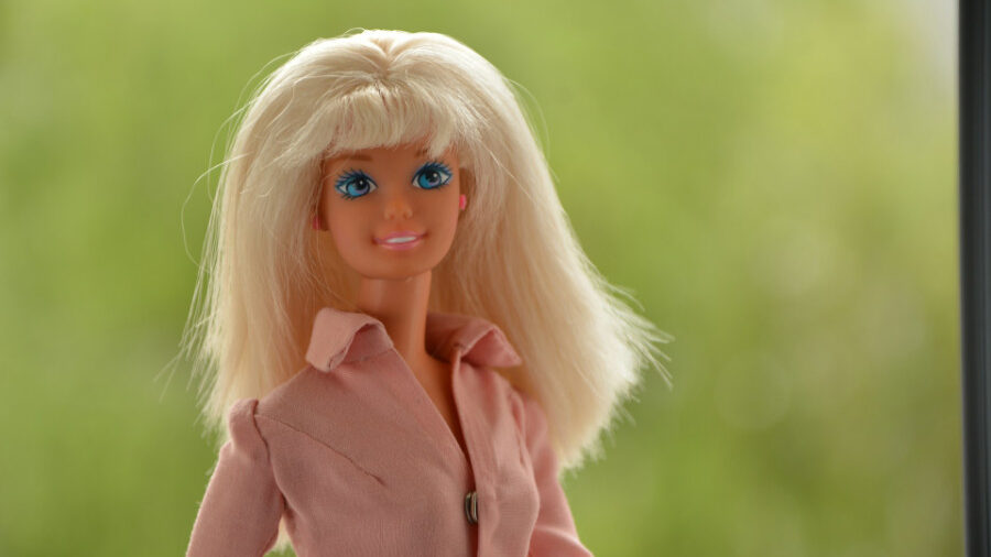 Muñeca Barbie con cabello rubio que lleva una camisa rosa