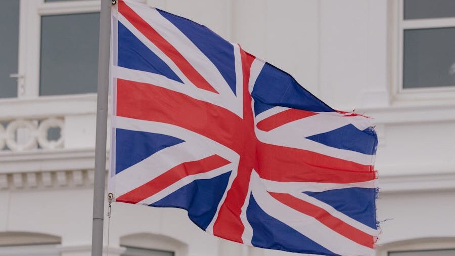 La bandera del Reino Unido con un borde ligeramente deshilachado ondea contra un fondo claro.