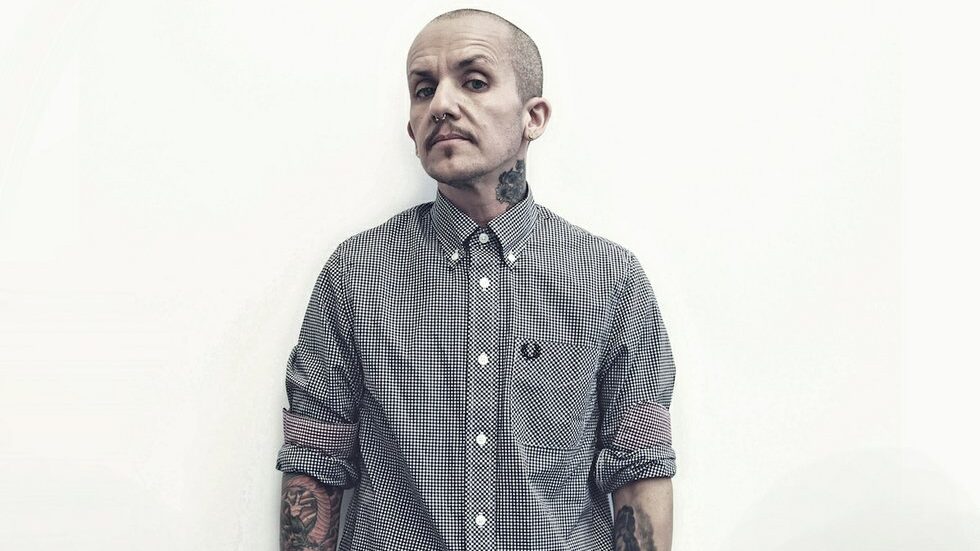 Lucas Silveira frente a una pared blanca con camisa Fred Perry para la campaña Anchor.