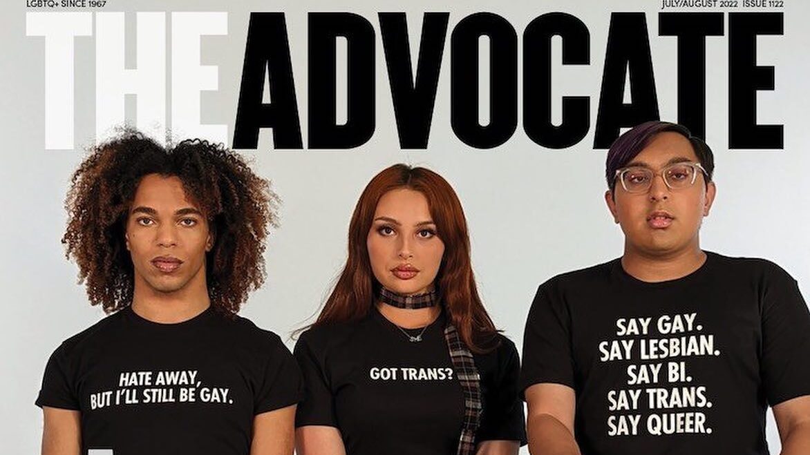 Zoey Luna sentada entre dos defensores de los derechos LGBTQ+ en la portada de The Advocate, todos llevan playeras audaces que muestran su activismo.