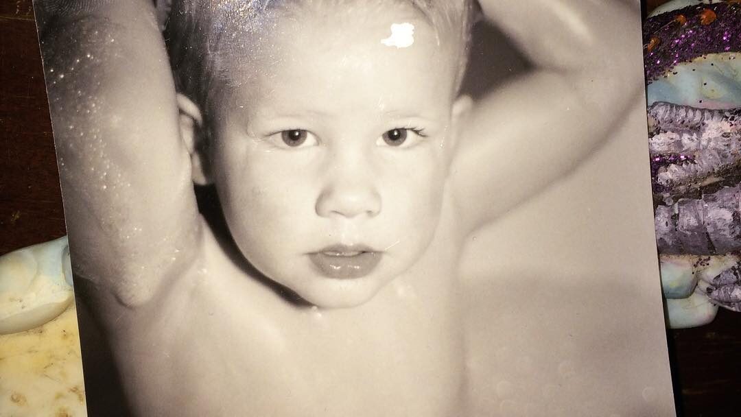 Foto en blanco y negro de una joven Willow Pill con el cabello mojado peinado hacia arriba y los brazos por encima de la cabeza.