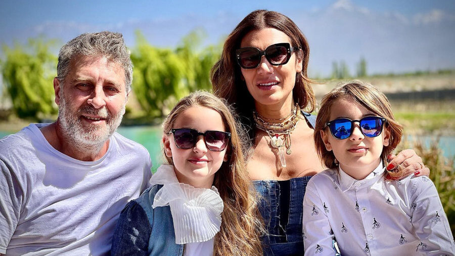 Florencia De La V sonríe con su esposo y sus hijos gemelos en una mesa de almuerzo al aire libre, todos con gafas de sol.