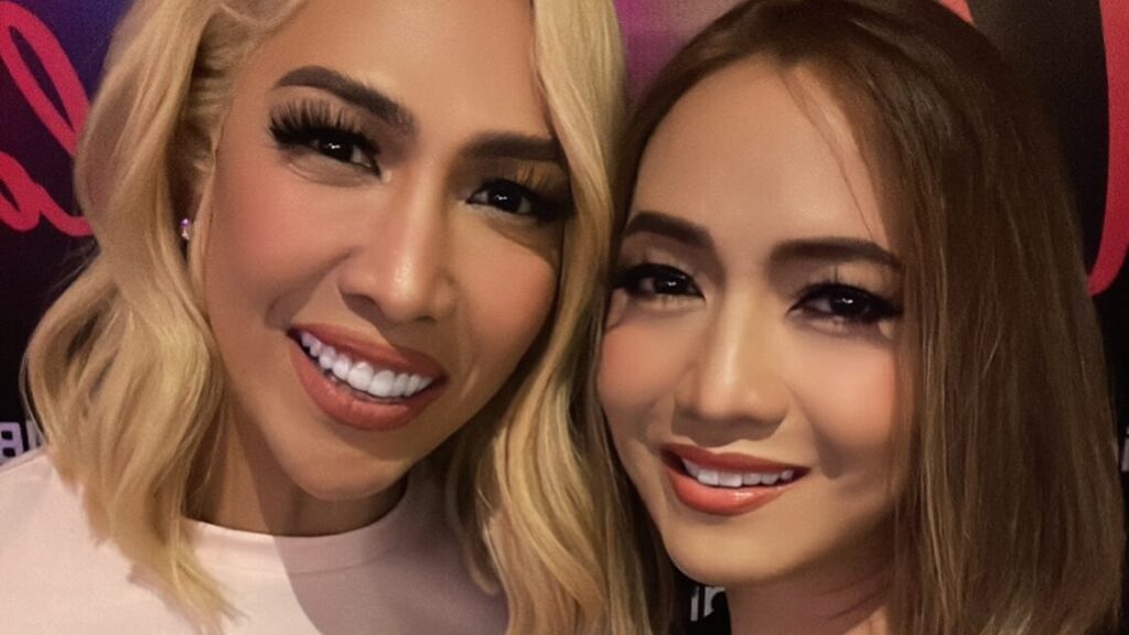 Las figuras públicas Vice Ganda y Anton Diva fotografiadas juntas sonriendo en una reunión social, con un fondo de vida nocturna en interiores.
