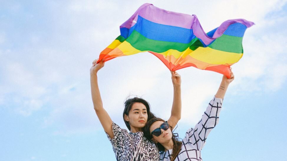 Couple de personne lesbienne tenant un drapeau LGBT