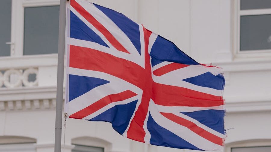 Le drapeau du Royaume-Uni avec un bord légèrement effiloché, flottant devant un arrière-plan clair.