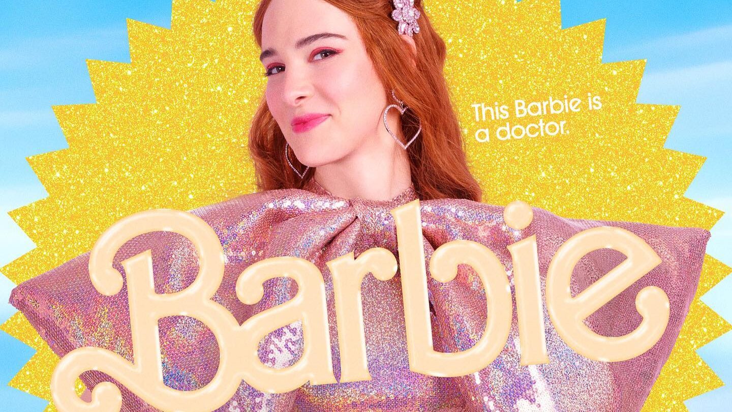 Affiche promotionnelle d’Hari Nef en tant que Docteur Barbie dans le film Barbie (2023). Elle porte une robe rose scintillante avec des épaules dramatiques, se tenant devant un fond jaune et bleu vif.