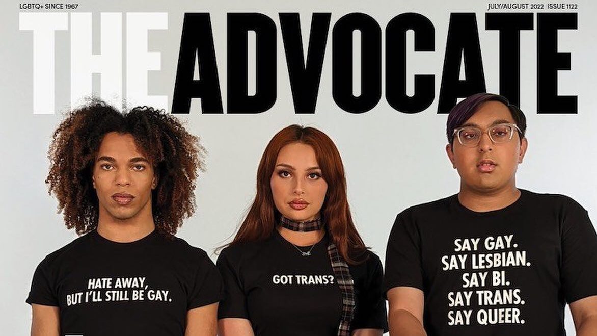 Zoey Luna assise entre deux militants LGBTQ+ sur la couverture 2022 de The Advocate, tous en t-shirts militants.