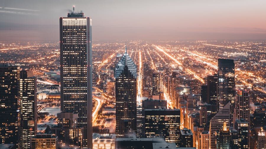 Vue nocturne du centre-ville de Chicago avec de hauts gratte-ciel et de longues rues éclairées s’étendant au loin.